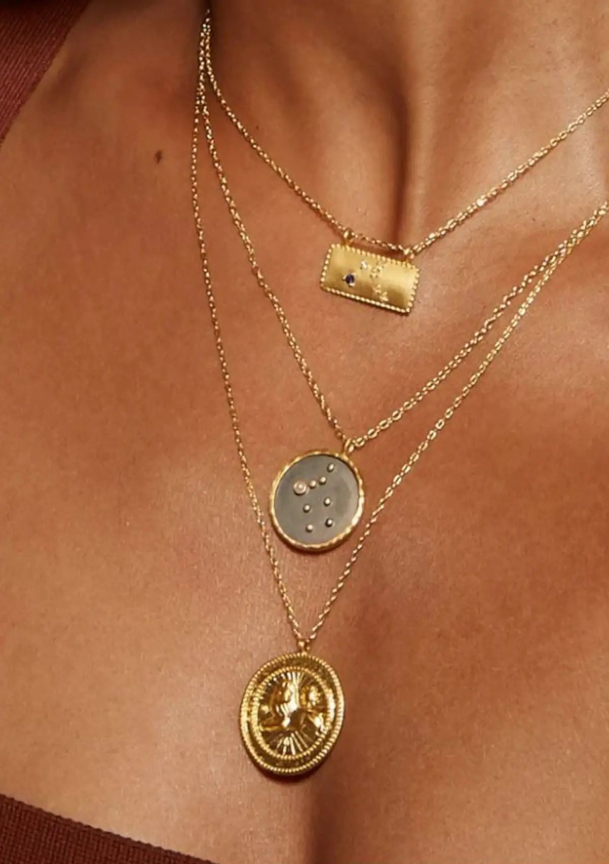 Paired with other gold necklaces and maroon shirt.